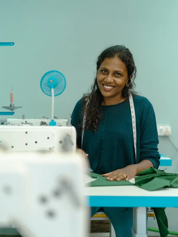 Smiling at the sewing machine in the Neeraazhi studio