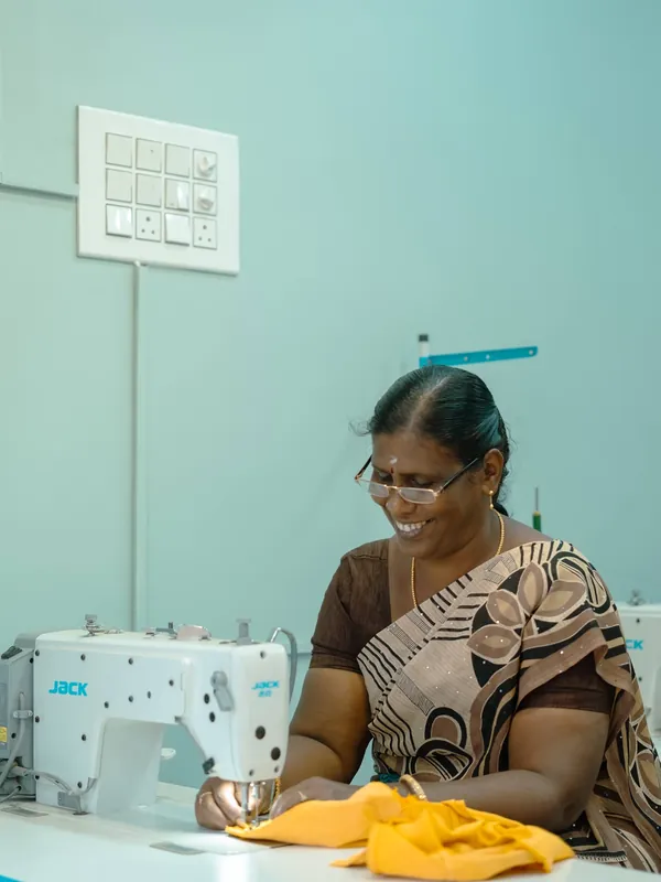 Tailor stitching yellow fabric at the machine
