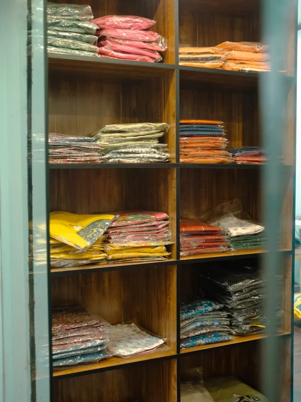 Wooden shelves stacked with folded fabrics