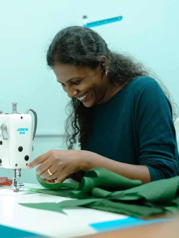 Stitching green fabric at the sewing machine