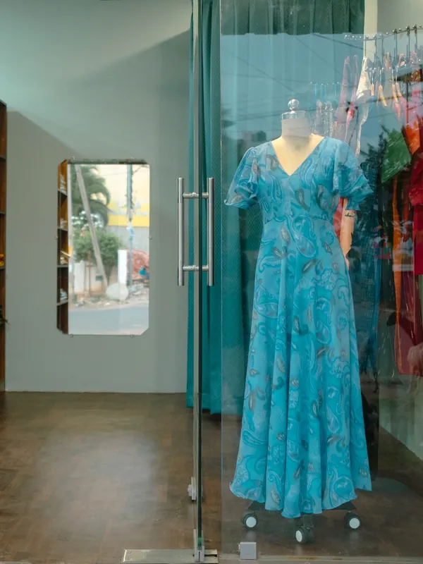 Blue printed dress on a mannequin inside the shop